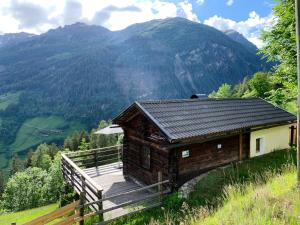 a small building on a hill with mountains in the background at Badstube Lex in Großkirchheim