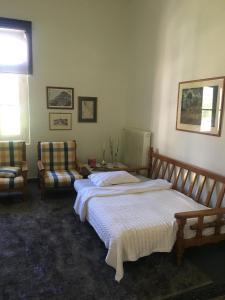 - une chambre avec un lit et deux chaises dans l'établissement Aggelis Traditional Appartment, à Sparte