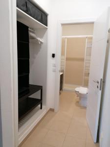 a bathroom with a toilet and a bathroom with white walls at Guia Guest House in São Bartolomeu de Messines +46 photos