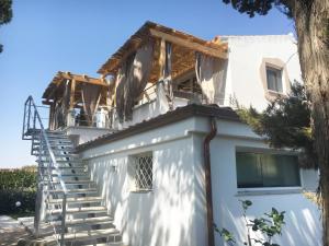 奧爾比亞的住宿－Sea Love，白色房子的一侧有楼梯