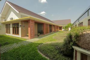 uma casa com um relvado em frente em IDR Green Guest House Syariah Mitra RedDoorz em Surakarta