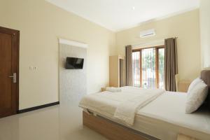IDR Green Guest House Syariah Mitra RedDoorz tesisinde bir odada yatak veya yataklar