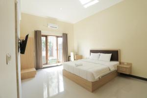 sypialnia z łóżkiem i dużym oknem w obiekcie IDR Green Guest House Syariah Mitra RedDoorz w mieście Surakarta