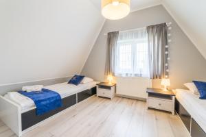 1 dormitorio con 2 camas y ventana en ApartamentyGdanske EU - Golden, en Gdansk