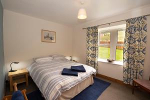 1 dormitorio con cama y ventana en Martinshouse Holiday Cottage, en Hawick