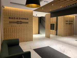 - un hall avec une chaise et un mur avec un panneau dans l'établissement Marina Blue-Apartament przy promenadzie, à Ełk