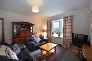 a living room with a couch and a table at Martinshouse Holiday Cottage in Hawick