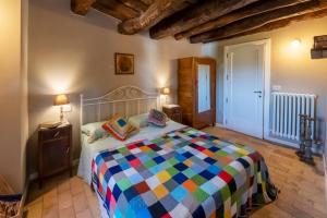 Borgo Case Lucidi relax في Torano Nuovo: غرفة نوم مع سرير مع لحاف ملون