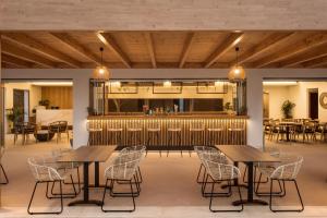 a restaurant with tables and chairs and a bar at Malena Hotel & Suites - Adults Only by Omilos Hotels in Amoudara Herakliou