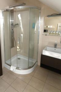 uma casa de banho com um chuveiro e um lavatório. em Ezüsthíd Hotel em Veszprém