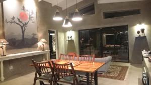 a dining room with a wooden table and chairs at Kruger River Villas - LionsGate in Marloth Park +7 photos