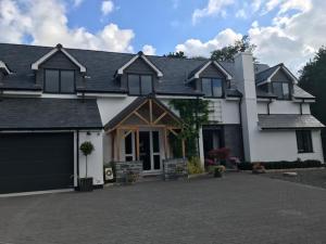a large white house with a large driveway at Riverside Stay in Gunnislake