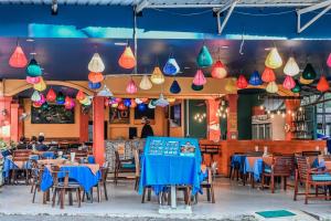 a restaurant with tables and chairs and colorful lights at Sugar and Spice Inn in Kata Beach