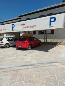 a car dealership with two cars parked in a parking lot at Villa Bunski biser in Blagaj