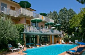 a hotel with a swimming pool with chairs and umbrellas at Residence Castiglione in Castiglione del Lago
