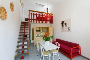 um quarto com uma mesa e um banco vermelho e uma escada em Residence Castiglione em Castiglione del Lago