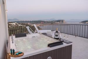 a hot tub on a balcony with a view of the ocean at GRAND HOTEL SERAPIDE in Pozzuoli