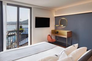 a hotel room with a bed and a large window at Hotel SANSEbay in Donostia-San Sebastián
