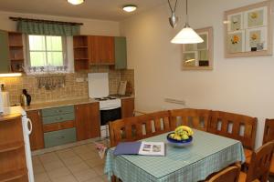 a kitchen with a table with a bowl of fruit on it at Ubytovani Zdarske vrchy in Světnov