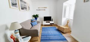 a living room with a couch and a blue rug at Velha 34 in Albufeira