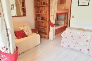 ein Wohnzimmer mit Couch und ein Schlafzimmer mit Etagenbett in der Unterkunft Les 2 alpes, charmant et authentique 4-6 personnes in Mont-de-Lans