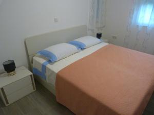 Un dormitorio con una cama con almohadas azules y blancas. en Apartman Pajo, en Primošten
