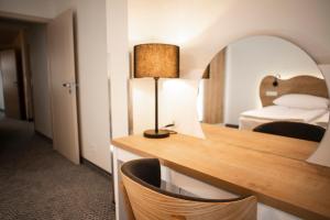 ein Hotelzimmer mit einem Bett und einem Schreibtisch mit einer Lampe in der Unterkunft Apartmány Koflík in Strakonice