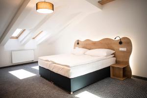 Schlafzimmer mit einem großen Bett mit einem Kopfteil aus Holz in der Unterkunft Apartmány Koflík in Strakonice
