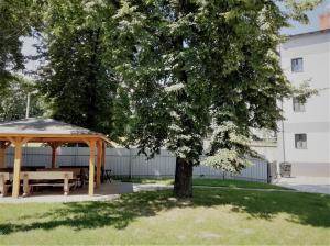a picnic table under a gazebo next to a tree at Apartmány Stdaniela in Bohumín