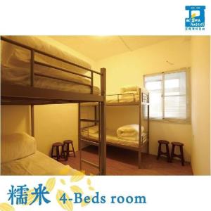 台東市的住宿－宏隆米絞青旅民宿 ，带凳子的客房内的两张双层床