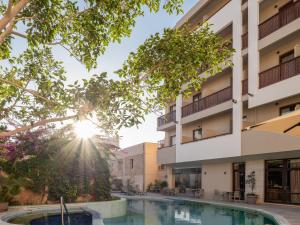 a view of a building with a pool and trees at Hotel Ideon in Rethymno