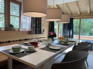 a dining room with a large white table and chairs at Alpenchalet Iseler in Oberjoch