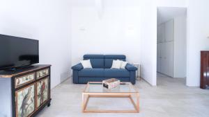 ein Wohnzimmer mit einem blauen Sofa und einem TV in der Unterkunft Italianway - Crosa dell'Oro 20 in Santa Margherita Ligure