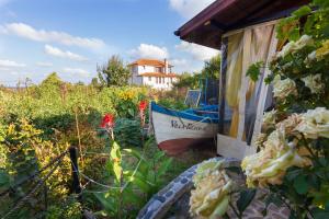 a garden with flowers and a boat in the background at Villa Rezos in Rezovo