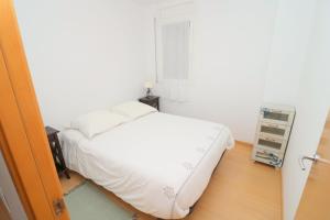 a bedroom with a white bed and a window at R. MARINE II (231) in Roses +17 photos