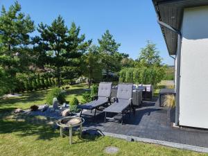 a patio with a group of chairs and a table at Jurates Villa in Palanga