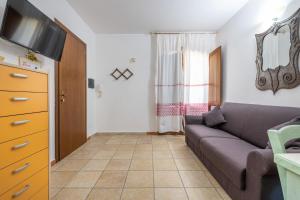 Una sala de estar con un sofá y un televisor. en Sapposentu de Dinu, en SantʼAnna Arresi