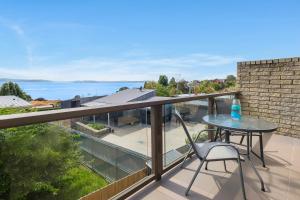 a patio with a table and chairs on a balcony at Self Contained Beach View Apartment in Kingston Beach