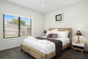 Un dormitorio con una cama grande y una ventana en Self Contained Beach View Apartment en Kingston Beach