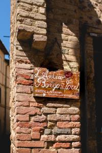 un panneau sur le côté d'un bâtiment en briques dans l'établissement Antico Borgo di Torri, à Sovicille