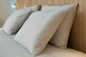 a group of pillows sitting on top of a bed at Un Air de Famille in Vittel