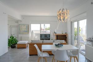アルテミダにあるYoga Euphoria seaside apartmentのリビングルーム(白いテーブル、椅子付)