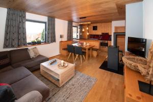 ein Wohnzimmer mit einem Sofa und einem Tisch in der Unterkunft Landhaus Bergheimat in Rauris