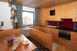eine Küche mit Holzvertäfelung, einem Holztisch und einem Tisch mit einem sidx sidx sidx in der Unterkunft Landhaus Bergheimat in Rauris