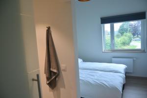 ein Schlafzimmer mit einem Bett und einem an der Wand hängenden Handtuch in der Unterkunft Villa Charles in Francorchamps