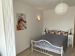 1 dormitorio con 1 cama y una pintura en la pared en Ferienwohnung am Obstgarten, en Bad Bocklet