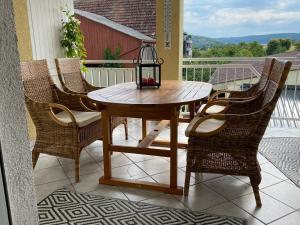 a wooden table with chairs and a lantern on a balcony at Ferienwohnung am Obstgarten in Bad Bocklet