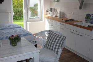 una cucina con tavolo, sedie e lavandino di ❤️ KLEINE AUSZEIT ❤️ a Hohwacht