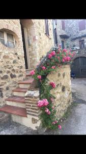 un edificio de piedra con un ramo de flores rosas en Rosa di Maggio, en Pari
