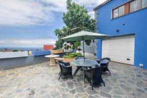 a patio with a table and chairs and an umbrella at Casa Las Cañas in Icod de los Vinos